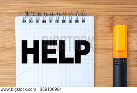 Business Concept. On The Wooden Table Is A Marker And A Notebook With The Inscription Help. Business
