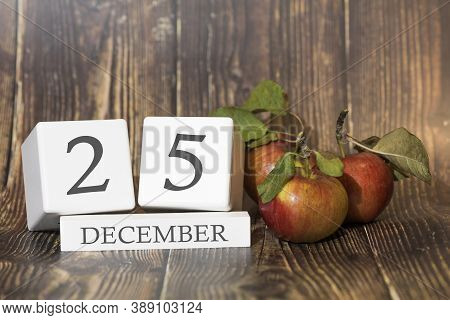 December 25. Day 25 Of Month. Calendar Cube On Wooden Background With Red Apples, Concept Of Busines