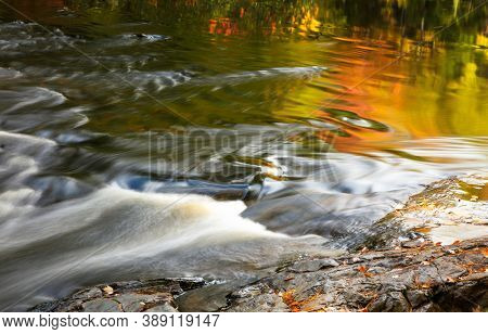 Colorful autumn tree reflections in Dead river water falls in Michigan upper peninsula