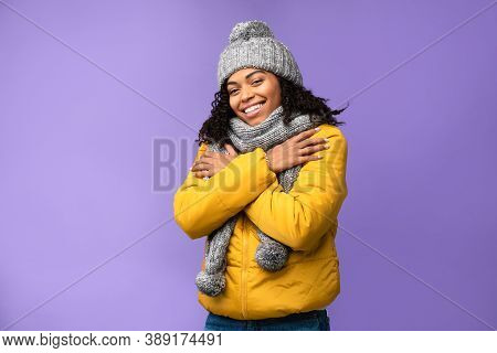 Winter Clothing. Happy African American Woman Wearing Warm Jacket, Cap And Scarf Standing Posing In 