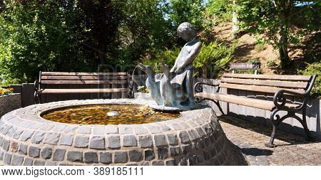 Schalkenmehren, Germany - June 23, 2020: Close Up Image Of The Fountain Of The Eifelverein With Benc