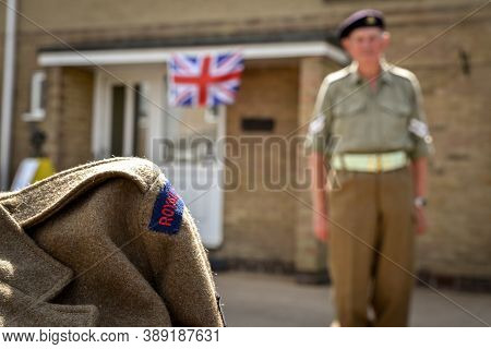 Ackworth, Uk - May 08, 2020: A Soldier Clad In Old Uniform Come Out From  His House To Celebrate 75t