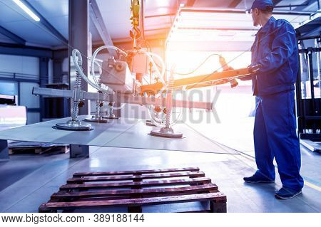 Worker Uses Suction Cups For Transporting Large Sheets Of Metal