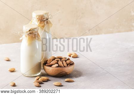 Vegan Almod Milk And Cream In Bottles, Closeup, Brown Background. Non Dairy Alternative Milk. Health