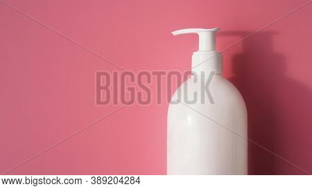 A White Antiseptic Pump Bottle On A Light Pink Background