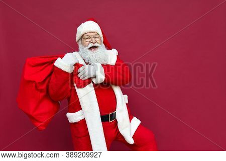 Happy Old Funny Santa Claus, Saint Nicholas Wearing Costume Holding Sack Bag With Merry Christmas Pr