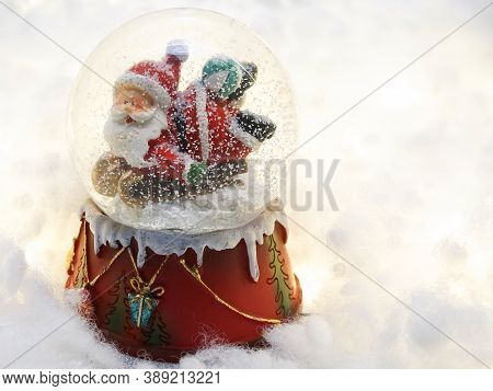 Santa Claus doll on a bucket in the middle of snow in the winter Christmas season