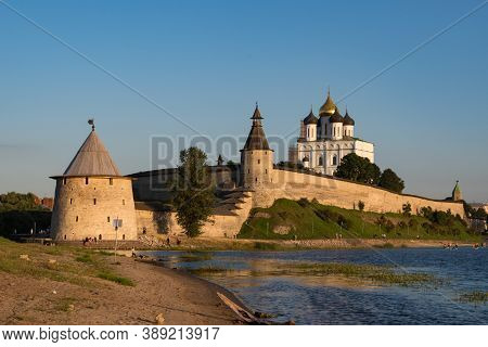 Pskov Kremlin View From River Pskova Creek. Towers, Wall And Trinity Cathedral On Background.