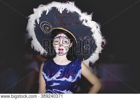 Merida, Mexico - 31 October 2018: Woman Dressed As Catrina With Flower Skull Make Up And Big Hat Wit