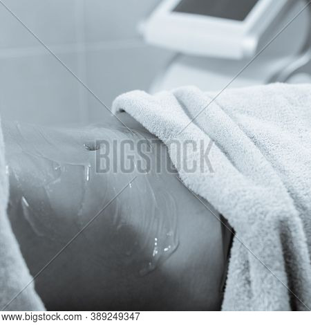 Woman Waiting For Vaccuum Massage Procedure To Reduce Cellulite. Black And White Image With Blue Tin