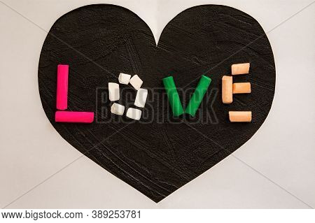 Multi-colored Pastel Crayons On A Black Background. The Word Love From Colored Pencils. Symbol Of Lo