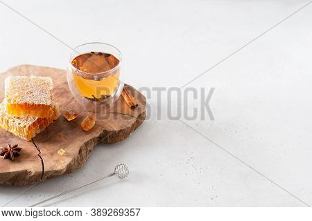 Strengthening Immunity In Autumn. Hot Tea In A Glass Cup, Honey Combs And Spieces On A Wooden Tray O