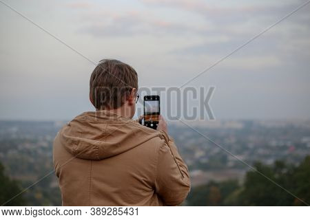 Man Taking A Photo Of A Landscape Using His Phone