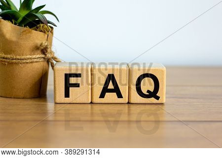 Concept Word 'faq' On Cubes On A Beautiful Wooden Table, White  Background. House Plant. Business Co