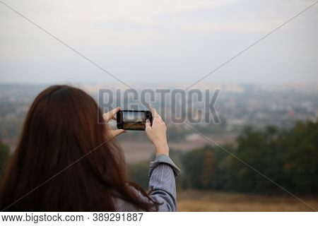 Woman Taking A Photo Of The Landscape Using Phone