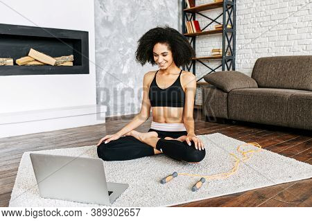 Fresh And Positive Attractive Female Millennial Is Watching Online Yoga Classes On The Laptop And Re