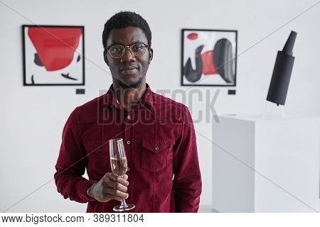 Waist Up Portrait Of Smiling African-american Man Holding Champagne Glass And Looking At Camera Whil