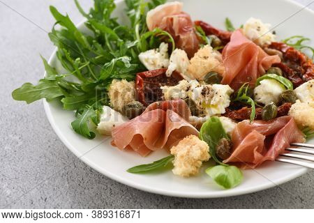 Salad Arugula, Parma Ham With Sun-dried Tomatoes, Mozzarella Slices, Croutons, Capers, Seasoned Oil 