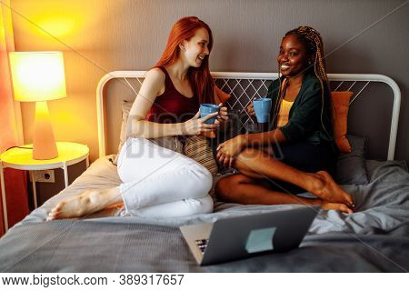 Cheerful Afro And European Lesbian Women At Home On The Bed