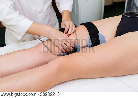 Installing The Electrodes Of The Muscle Myostimulation Device On The Body Of A Young Woman In The Sp