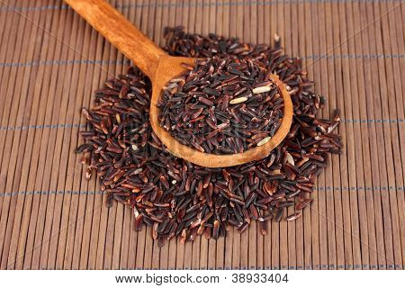 arroz preto com colher de pau, na esteira de bambu