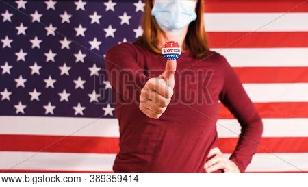 Woman With I Voted Today Sticker On Thumbs Up Finger And Face Mask At 2020 American Elections.