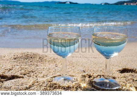 Two Glasses Of Local Dry White Wine On White Sandy Beach And Blue Mediterranean Sea On Background, N