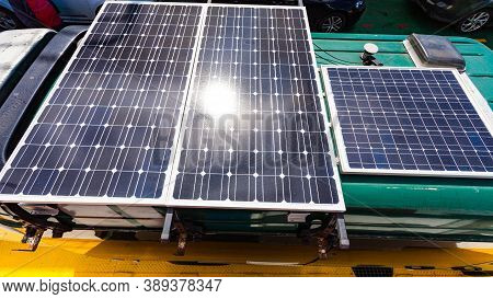 Tourism Vacation And Travel. Camper Van With Solar Photovoltaic Panels, Charging Batteries On Roof.