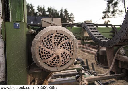 Fragment Of Mobile Sawing Equipment For Logs In The Open Air. Rural Landscape On A Sunny Day. Mobili
