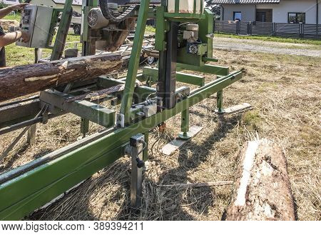 Mobile Sawing Equipment For Logs In The Open Air. Rural Landscape On A Sunny Day. Mobility And Work 
