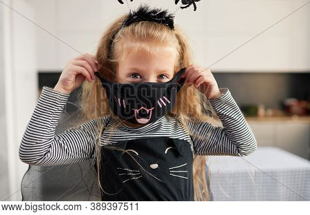 Funny Child Girl Dressed In Witch Canival Costume. Halloween Holiday During Quarantine Time