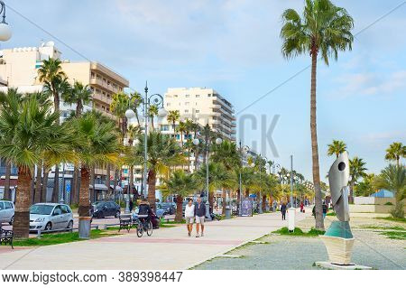 Larnaka, Cyprus - Feb 18, 2019: People Walking By Larnaca City Embankment With Typical Architecture 