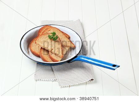 pão frito decorado com salsa, na panela de ferro