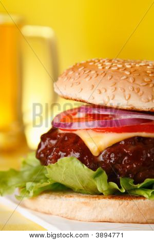 Chutné Cheeseburger s pintu piva na pozadí