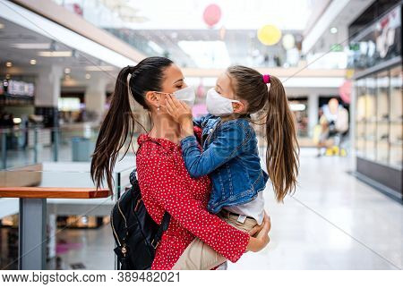 Mother And Daughter With Face Mask Standing Indoors In Shopping Center, Coronavirus Concept.