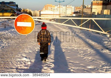 The Sign For Travel Is Prohibited. A Red Circle With A White Rectangle. Barrier On The Road. A Boy I