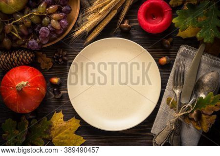 Thanksgiving Food Concept. Autumn Table Setting With Craft Plate, Silverware And Fall Decorations At