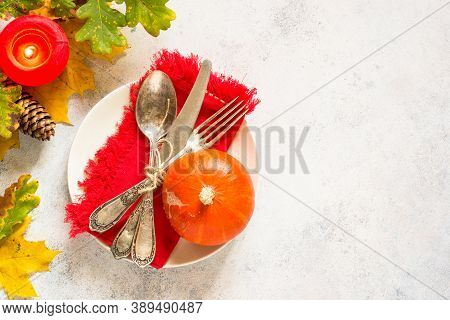 Autumn Table Setting With Craft Plate, Silverware And Fall Decorations At White Table. Top View With