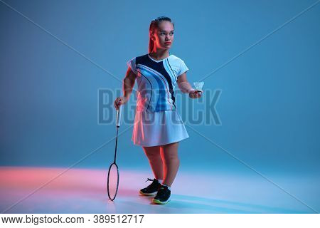 Leader. Beautiful Dwarf Woman Practicing In Badminton Isolated On Blue Background In Neon Light. Lif