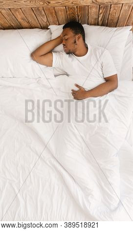 Asleep Black Man Sleeping With Eyes Closed Lying In His Comfortable Bed At Home. African Guy Resting
