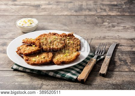 Traditional Jewish Latkes Or Potato Pancakes On Wooden Table