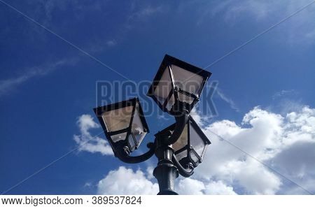 Street Lighting Three-light Lamp Post Against A Cloudy Sky