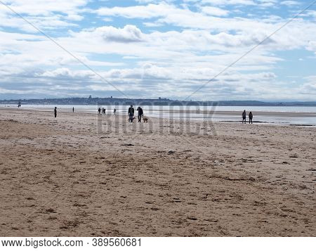 Southport, Merseyside, United Kingdom - 10 September 2020: People Walking On The Beach With Dogs At 