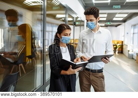 Businesspeople Discuss Workring Issues During Pandemic Of Coronavirus. Man And Woman Wearing Protect