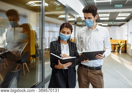 Businesspeople Discuss Workring Issues During Pandemic Of Coronavirus. Man And Woman Wearing Protect