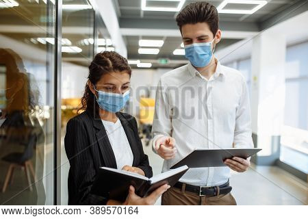 Businesspeople Discuss Workring Issues During Pandemic Of Coronavirus. Man And Woman Wearing Protect