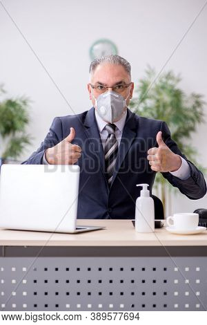 Old male boss employee working during pandemic