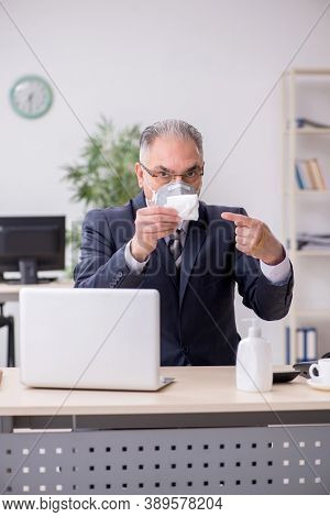 Old male boss employee working during pandemic