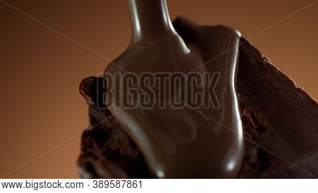 Detail of piece of chocolate with pouring hot chcocolate on top. Studio macro shot.