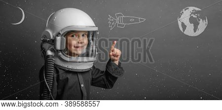 A small child imagines himself to be an astronaut in an astronaut's helmet. 
